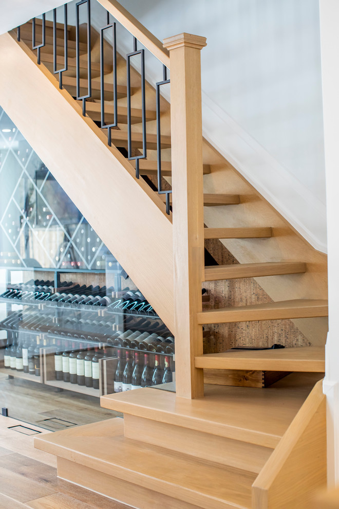 This is an example of a mid-sized modern wood l-shaped staircase in Toronto with open risers and metal railing.