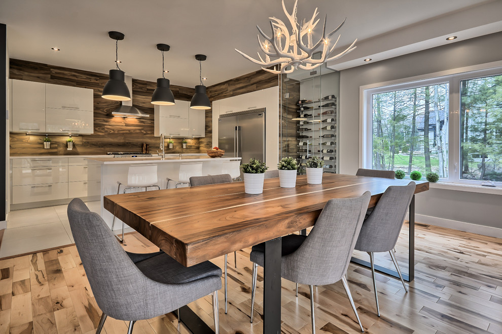 Design ideas for a mid-sized contemporary l-shaped eat-in kitchen in Montreal with an undermount sink, flat-panel cabinets, white cabinets, solid surface benchtops, porcelain splashback, stainless steel appliances, porcelain floors, with island and white floor.