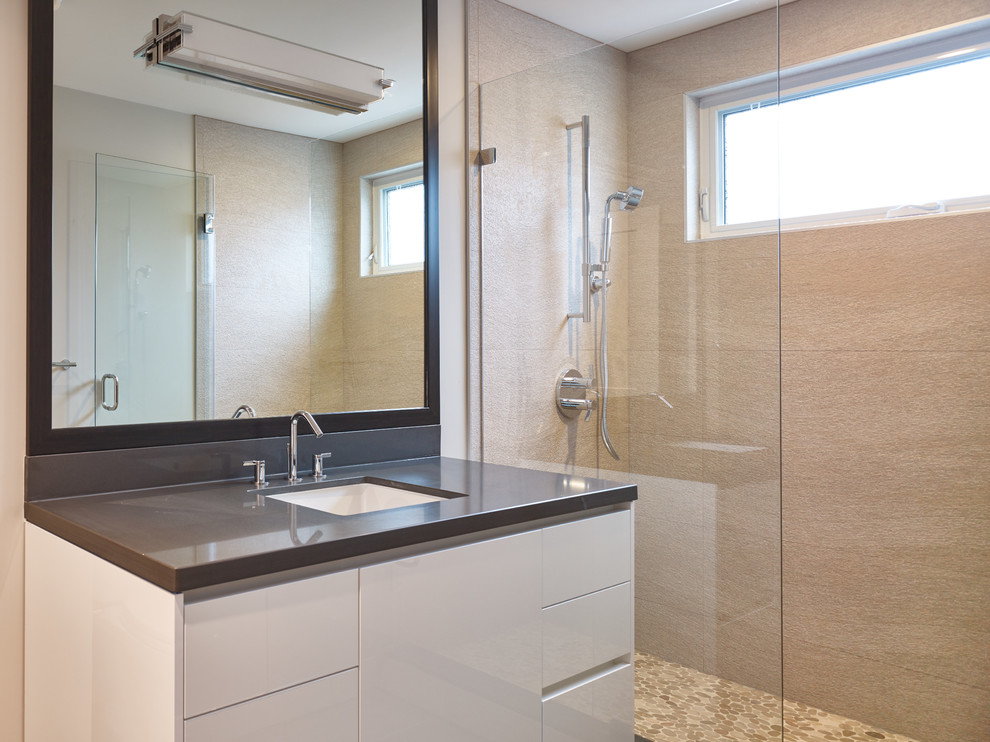 Photo of a contemporary bathroom in Vancouver with an undermount sink, flat-panel cabinets, granite benchtops, an alcove shower, beige tile, porcelain tile, beige walls, porcelain floors and white cabinets.