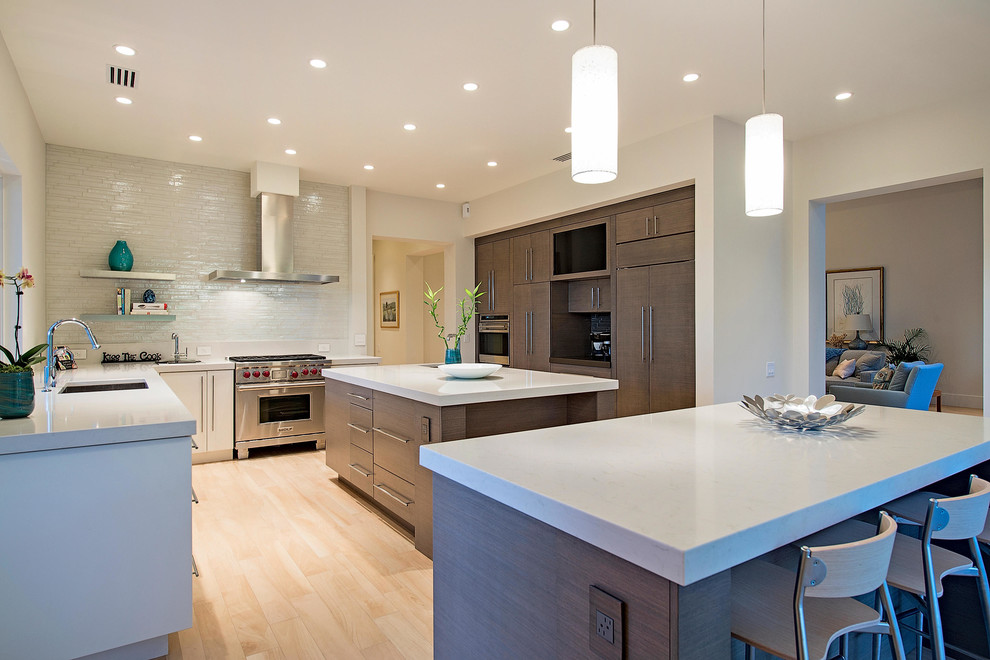 Design ideas for a large contemporary u-shaped eat-in kitchen in Miami with an undermount sink, flat-panel cabinets, grey cabinets, quartz benchtops, white splashback, glass sheet splashback, panelled appliances, porcelain floors and multiple islands.