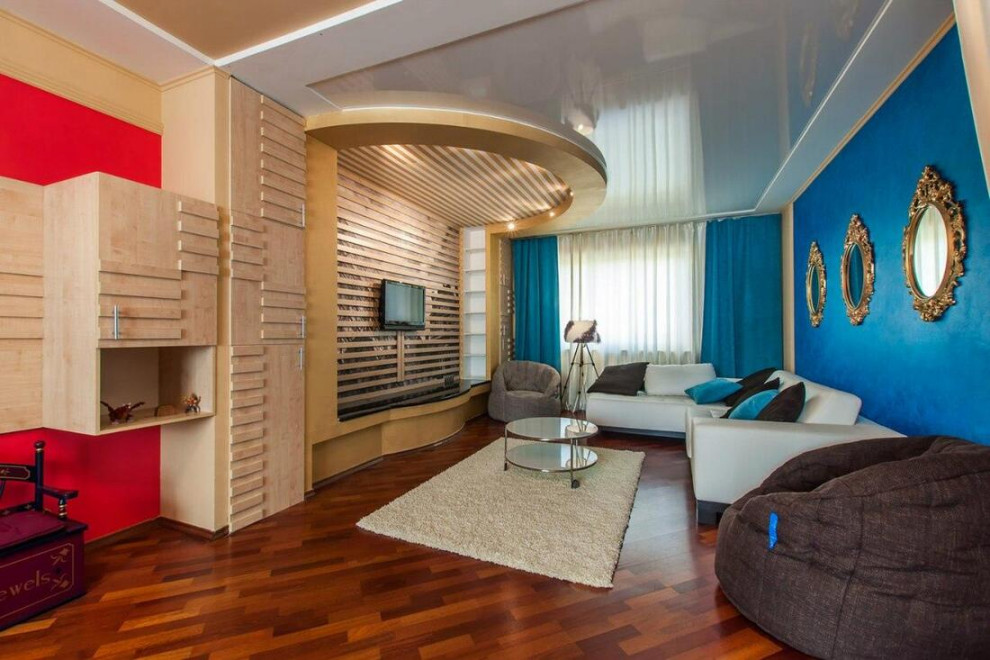 Идея дизайна: большая парадная, изолированная гостиная комната в современном стиле с синими стенами, темным паркетным полом, телевизором на стене, коричневым полом, обоями на стенах и синими шторами без камина