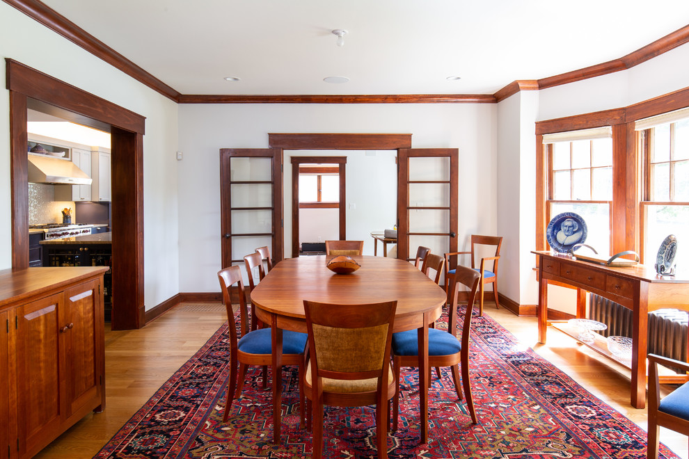 Photo of a mid-sized arts and crafts separate dining room in Kansas City with white walls, medium hardwood floors and brown floor.