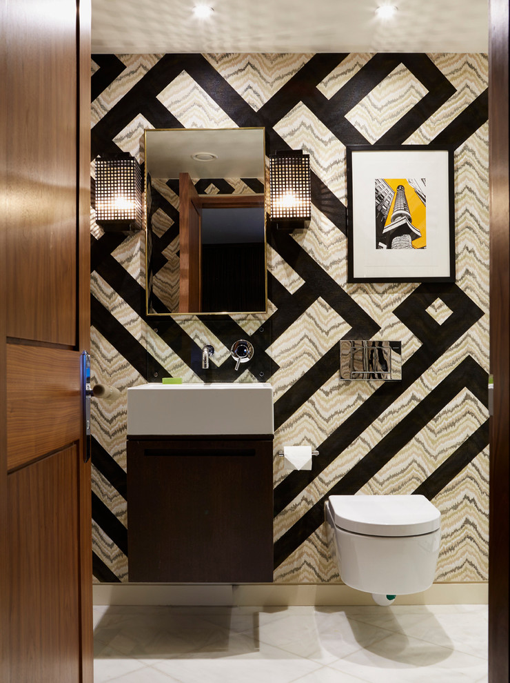 Photo of a contemporary powder room in London with flat-panel cabinets, dark wood cabinets, a wall-mount toilet, multi-coloured walls and a wall-mount sink.