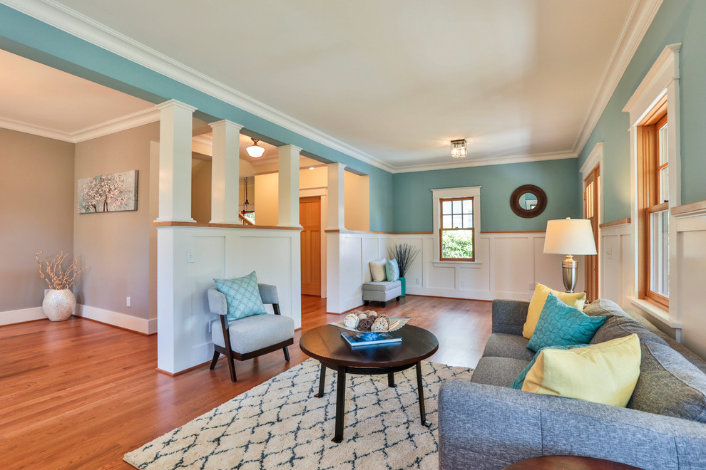 Mid-sized arts and crafts formal open concept living room in Seattle with blue walls, medium hardwood floors, a standard fireplace, a brick fireplace surround, no tv and brown floor.