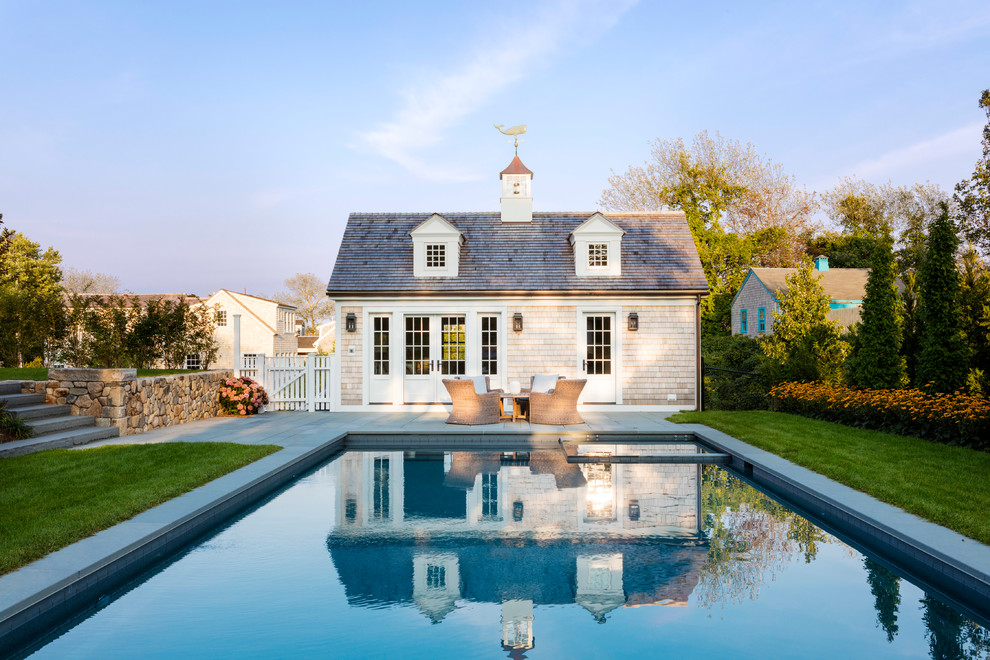 This is an example of a beach style backyard rectangular pool in Providence with a pool house.