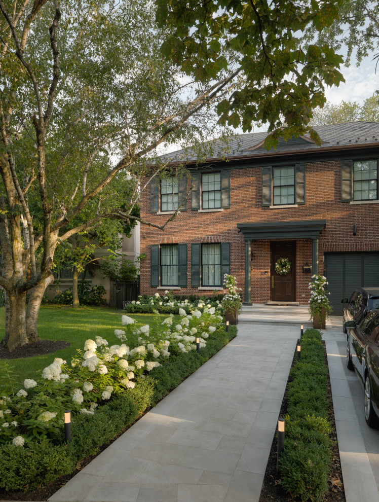 Inspiration for a small contemporary front yard partial sun formal garden in Toronto with with flowerbed and natural stone pavers.