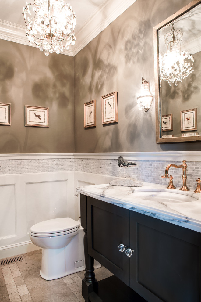Photo of a mid-sized traditional bathroom in St Louis with an undermount sink, shaker cabinets, brown cabinets, marble benchtops, a one-piece toilet, white tile, stone tile, grey walls and porcelain floors.