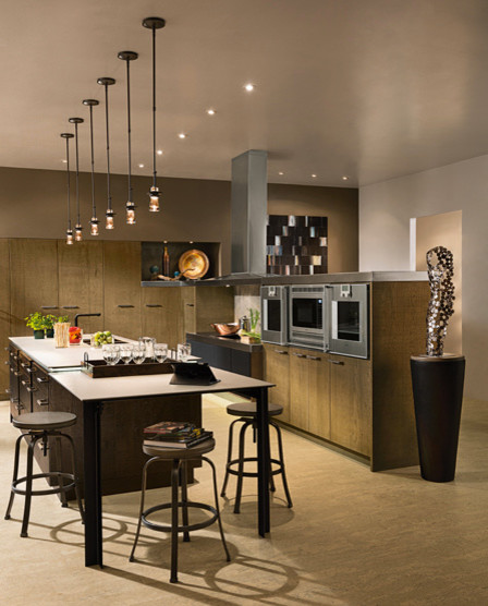 Example of a minimalist u-shaped eat-in kitchen design in Houston with light wood cabinets, stainless steel appliances and an island