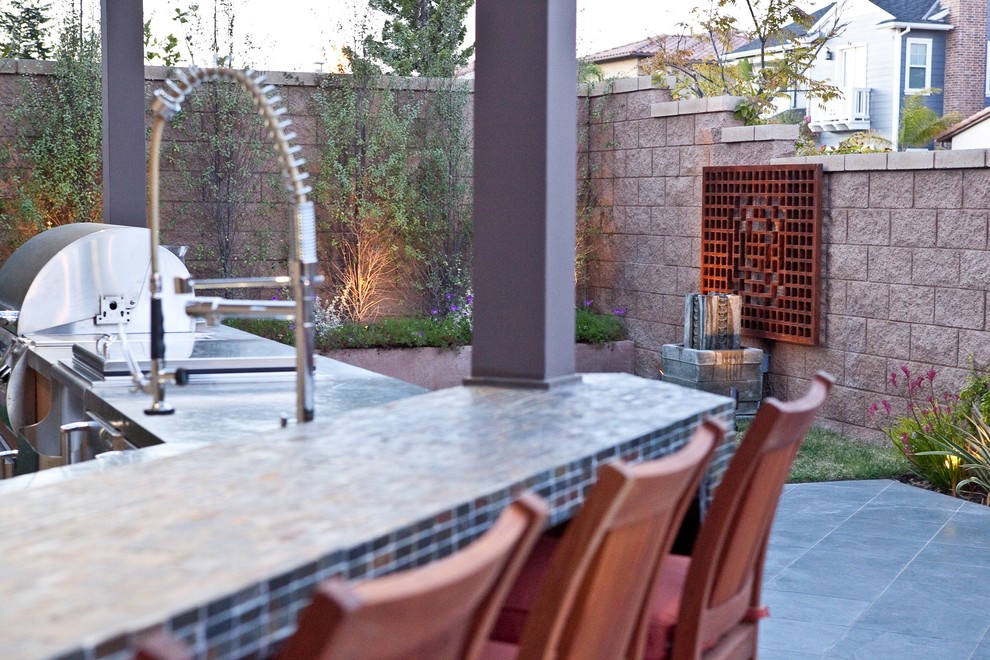Photo of a small eclectic backyard patio in Los Angeles with an outdoor kitchen, tile and a pergola.