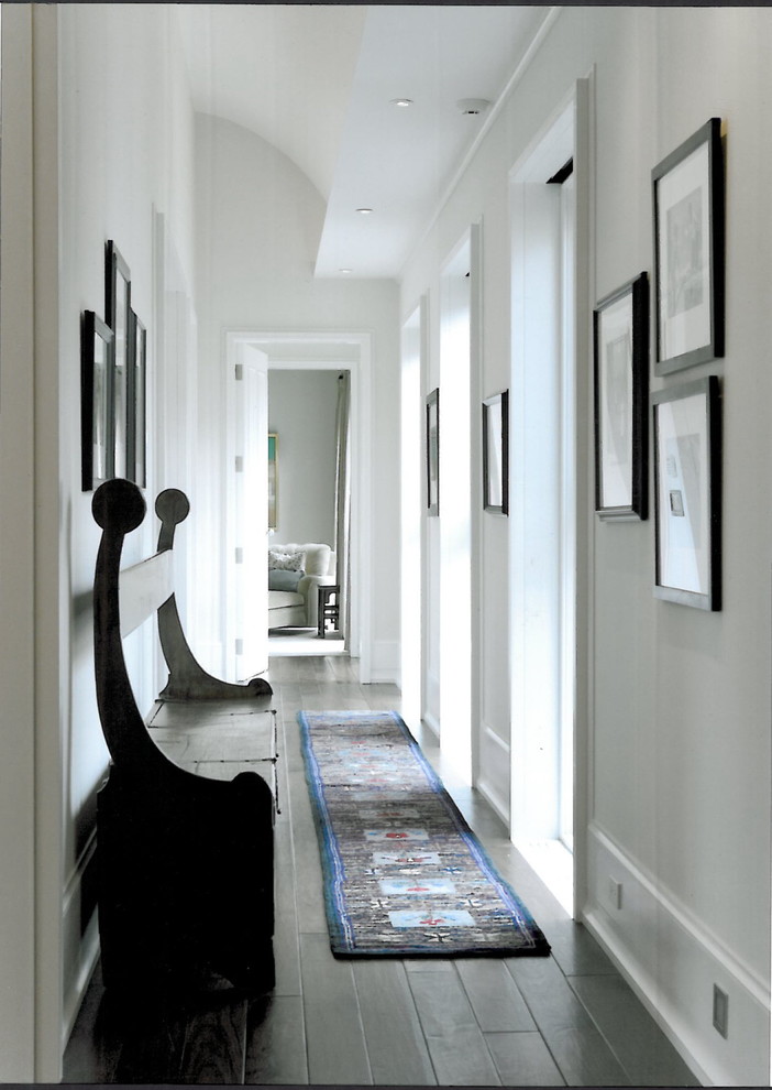 This is an example of a contemporary hallway in Chicago with white walls, dark hardwood floors and black floor.