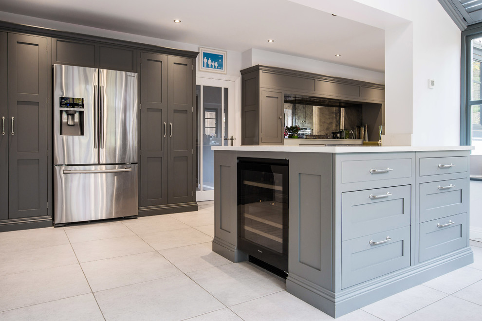 Photo of a mid-sized contemporary galley eat-in kitchen in Kent with an integrated sink, recessed-panel cabinets, grey cabinets, quartzite benchtops, metallic splashback, glass tile splashback, stainless steel appliances, limestone floors, with island, beige floor and white benchtop.