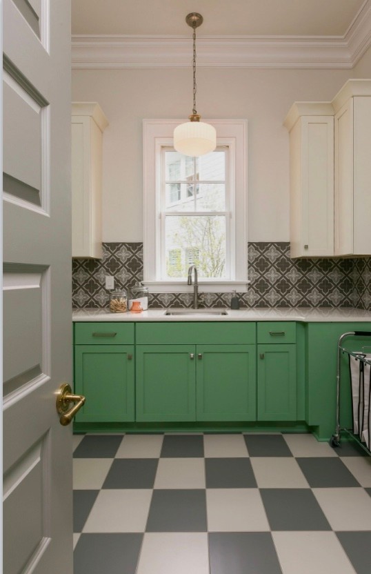 Photo of a large traditional l-shaped dedicated laundry room in Charleston with an undermount sink, shaker cabinets, green cabinets, solid surface benchtops, grey walls, porcelain floors, a side-by-side washer and dryer and grey floor.