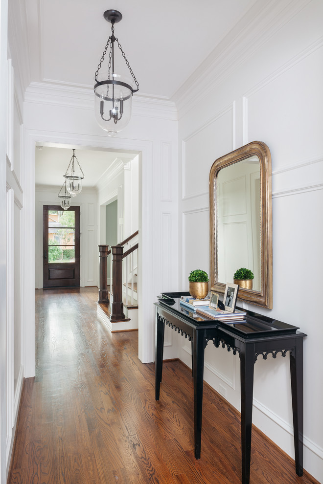 Photo of an expansive traditional hallway in Houston with white walls, medium hardwood floors, brown floor and panelled walls.