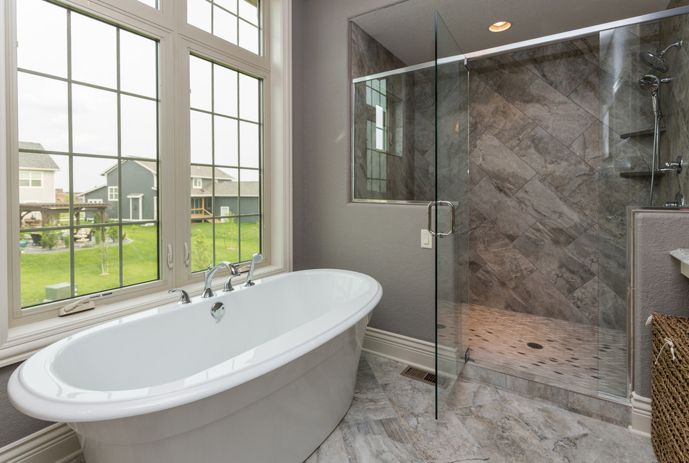 Transitional master beige tile freestanding bathtub photo with a vessel sink, white cabinets, quartz countertops, a two-piece toilet and gray walls