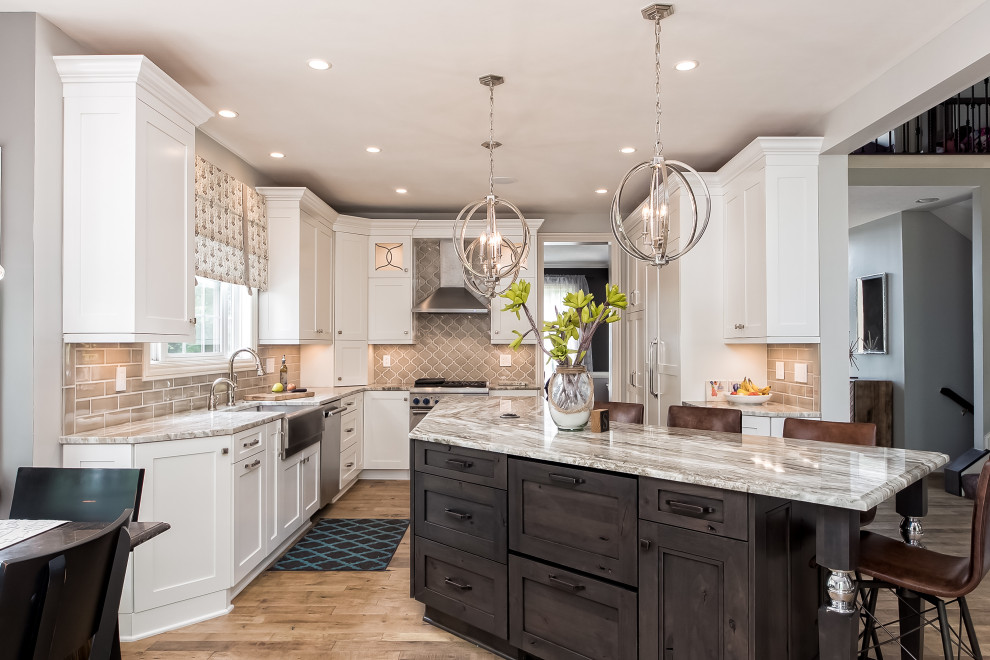 Inspiration for a transitional u-shaped eat-in kitchen in Columbus with a farmhouse sink, shaker cabinets, white cabinets, marble benchtops, beige splashback, subway tile splashback, panelled appliances, medium hardwood floors, with island, brown floor and multi-coloured benchtop.