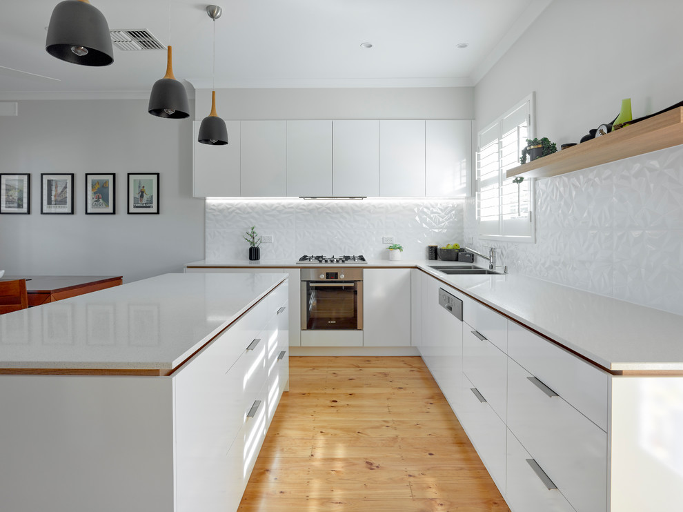 Photo of a large contemporary l-shaped kitchen in Other with a double-bowl sink, white cabinets, quartz benchtops, white splashback, ceramic splashback, stainless steel appliances, medium hardwood floors and with island.
