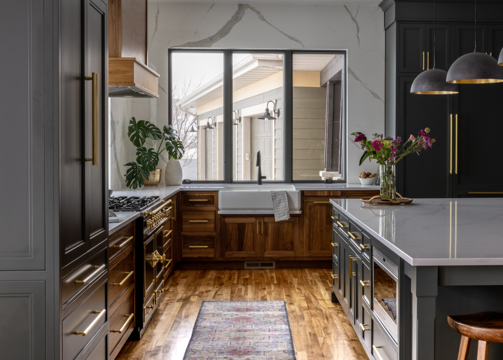 Eat-in kitchen - mid-sized transitional l-shaped light wood floor and brown floor eat-in kitchen idea with a farmhouse sink, shaker cabinets, blue cabinets, quartz countertops, white backsplash, quartz backsplash, black appliances, an island and white countertops