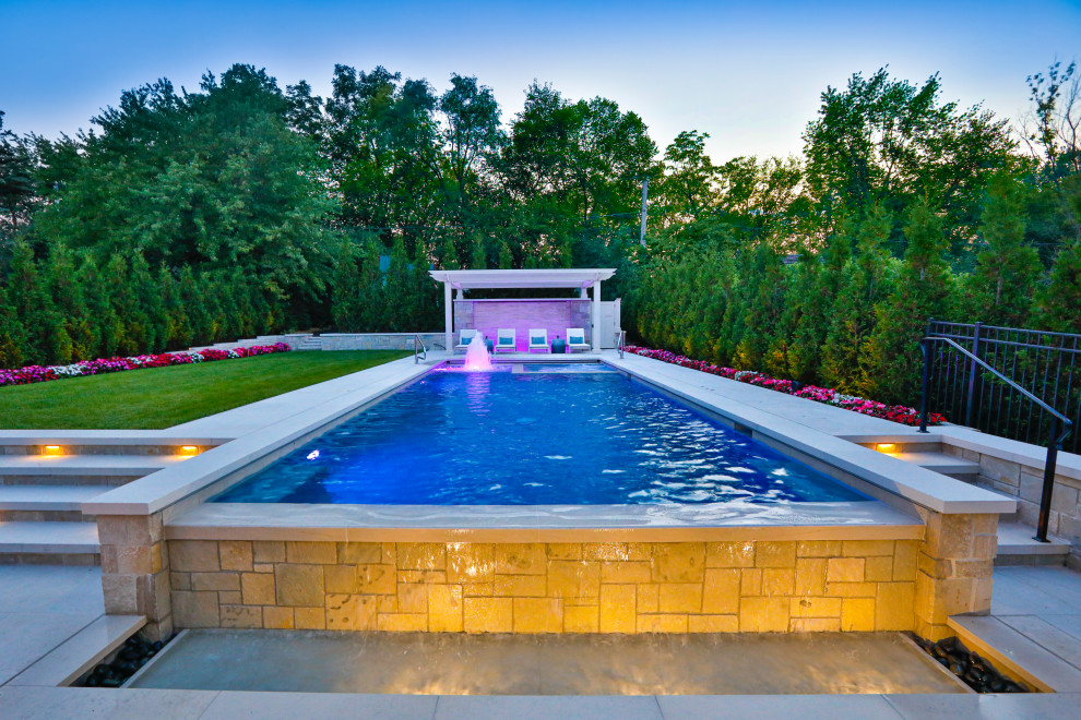 Immagine di una piscina monocorsia classica rettangolare di medie dimensioni e dietro casa con paesaggistica bordo piscina e pavimentazioni in pietra naturale