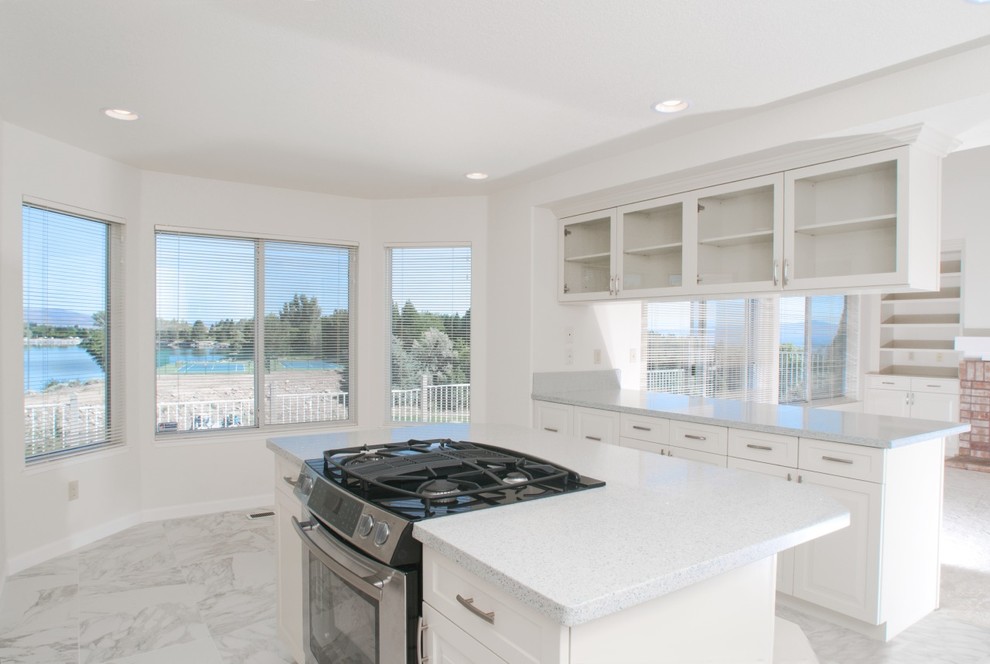 This is an example of a mid-sized traditional u-shaped eat-in kitchen in Other with a double-bowl sink, shaker cabinets, white cabinets, quartz benchtops, stainless steel appliances, marble floors and with island.