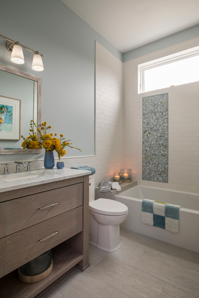 Inspiration for a beach style bathroom in Portland with medium wood cabinets, a one-piece toilet, blue tile, ceramic tile, blue walls, porcelain floors, an undermount sink, engineered quartz benchtops, beige floor, white benchtops, flat-panel cabinets and an alcove tub.