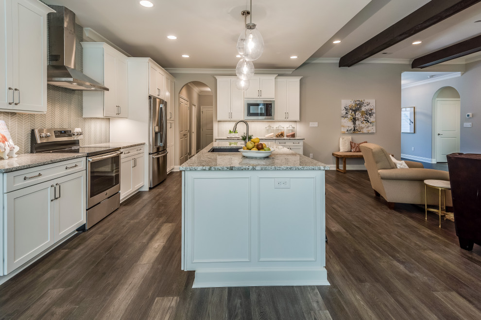 Open concept kitchen - mid-sized transitional l-shaped open concept kitchen idea with an undermount sink, flat-panel cabinets, white cabinets, quartz countertops, white backsplash, glass tile backsplash, stainless steel appliances, an island and white countertops