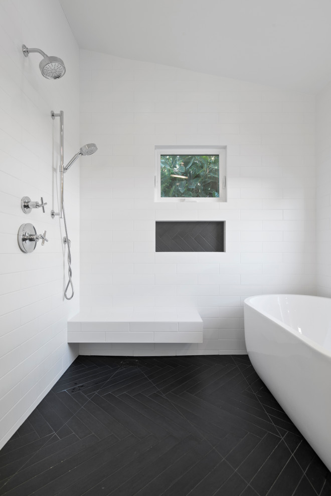 Photo of a large transitional master wet room bathroom in Los Angeles with furniture-like cabinets, brown cabinets, a freestanding tub, white tile, subway tile, porcelain floors, engineered quartz benchtops, black floor, a hinged shower door and white benchtops.