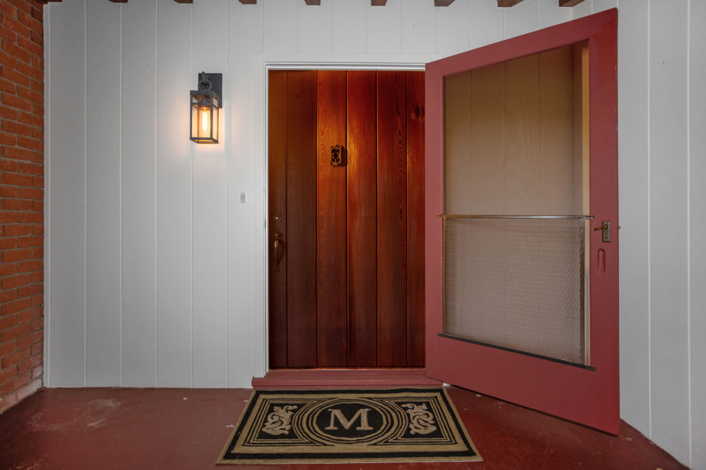 Idee per un'ampia porta d'ingresso stile americano con pareti bianche, pavimento in cemento, una porta singola, una porta in legno scuro, pavimento rosso e pareti in legno