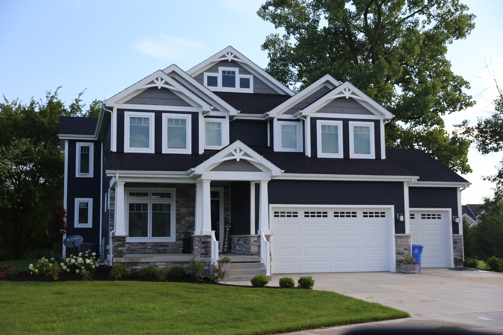 This is an example of a large arts and crafts two-storey blue house exterior in Chicago with wood siding, a gable roof and a shingle roof.