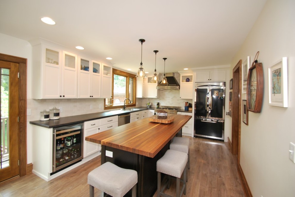 Inspiration for a mid-sized transitional l-shaped dark wood floor and brown floor enclosed kitchen remodel with recessed-panel cabinets, white cabinets, quartz countertops, beige backsplash, subway tile backsplash, stainless steel appliances and an island