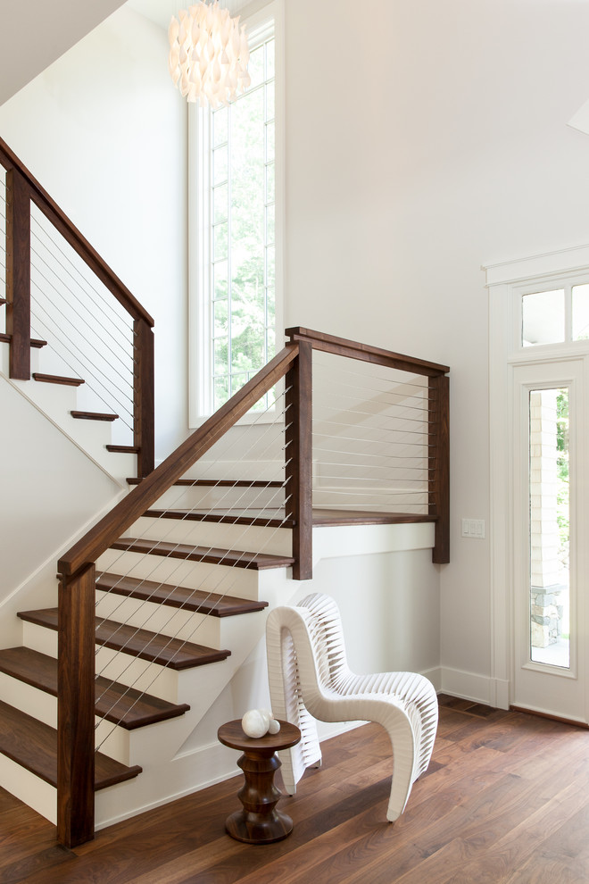 Large transitional wooden u-shaped cable railing staircase photo in Boston with painted risers