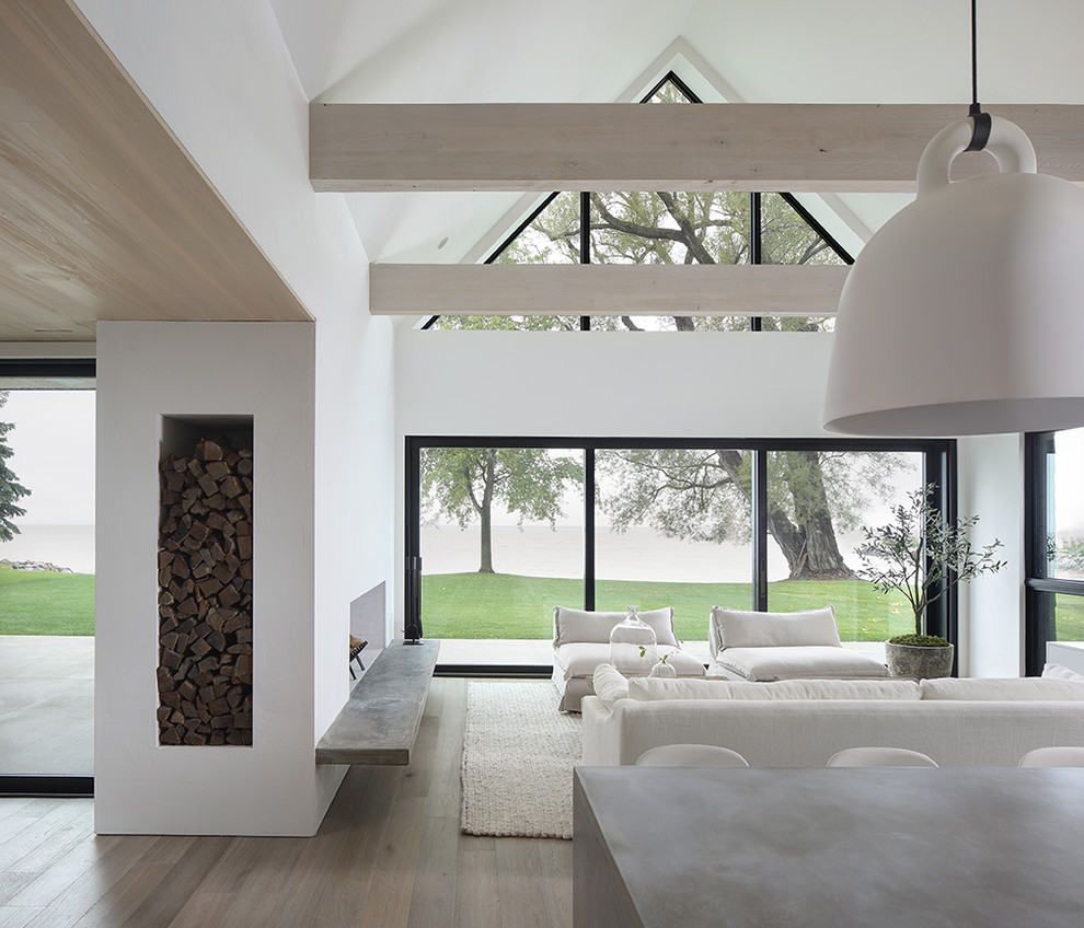 Living room - modern open concept light wood floor living room idea in Milwaukee with white walls, a standard fireplace and a plaster fireplace