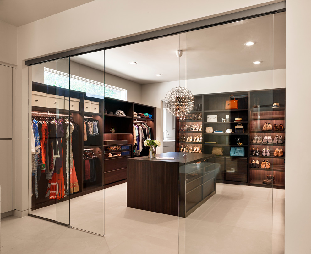 Inspiration for a contemporary women's dressing room in Austin with flat-panel cabinets and dark wood cabinets.