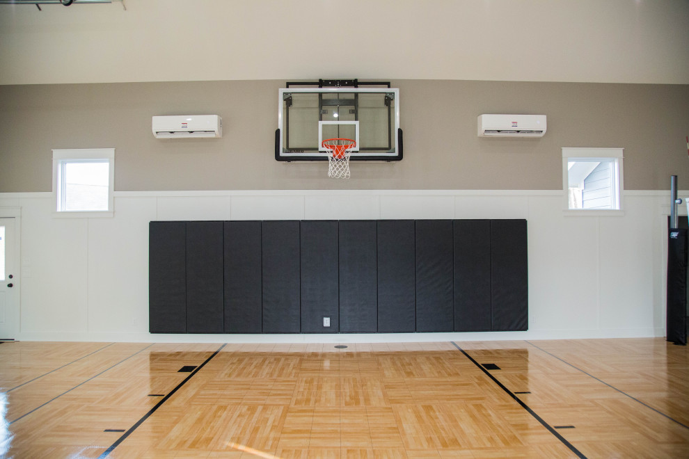 Großer Klassischer Fitnessraum mit Indoor-Sportplatz, weißer Wandfarbe und braunem Boden in Indianapolis
