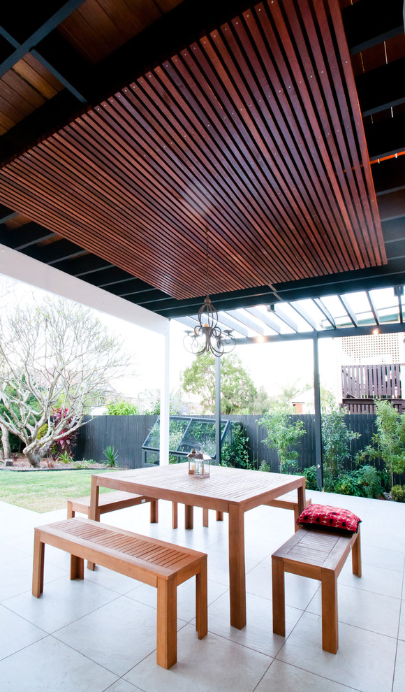 Inspiration for a transitional backyard patio in Brisbane with concrete slab and a roof extension.