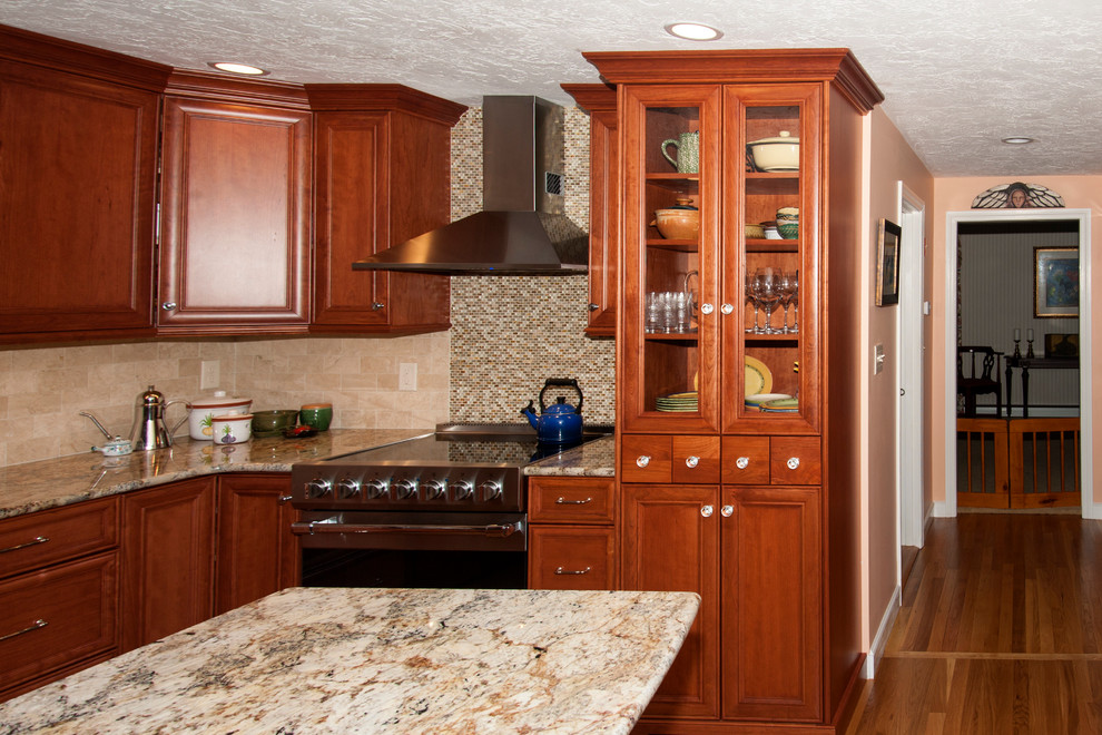 Example of a mid-sized transitional l-shaped eat-in kitchen design in Boston with a farmhouse sink, flat-panel cabinets, medium tone wood cabinets, granite countertops, beige backsplash, subway tile backsplash, stainless steel appliances and an island