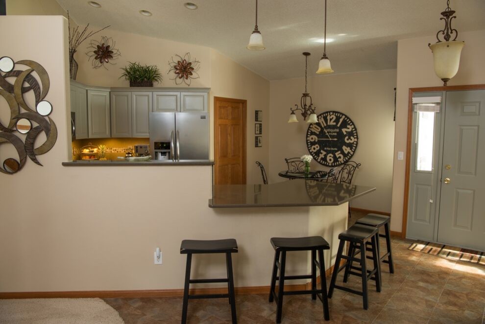 Small transitional l-shaped travertine floor and multicolored floor eat-in kitchen photo with raised-panel cabinets, a peninsula, a double-bowl sink, gray cabinets, granite countertops and stainless steel appliances
