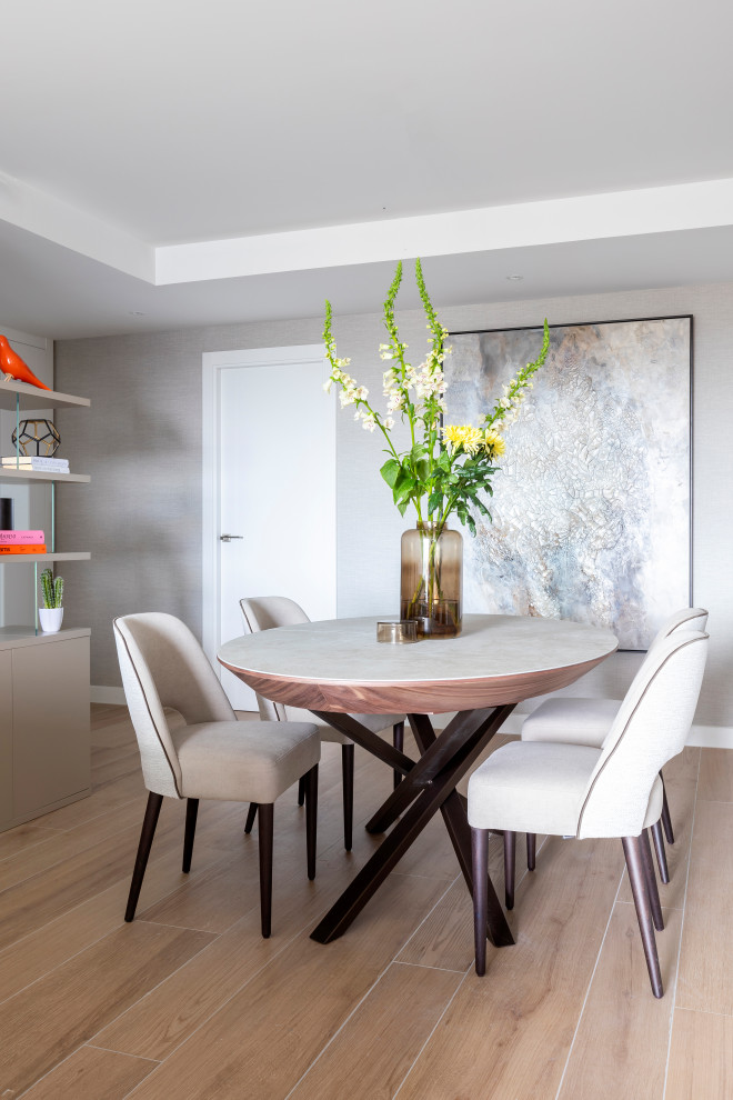 Foto de comedor contemporáneo con suelo de madera en tonos medios, papel pintado y cuadros
