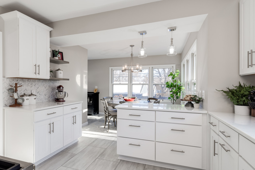 Small transitional u-shaped eat-in kitchen in Other with a single-bowl sink, shaker cabinets, white cabinets, quartz benchtops, grey splashback, marble splashback, stainless steel appliances, vinyl floors, a peninsula, beige floor and white benchtop.