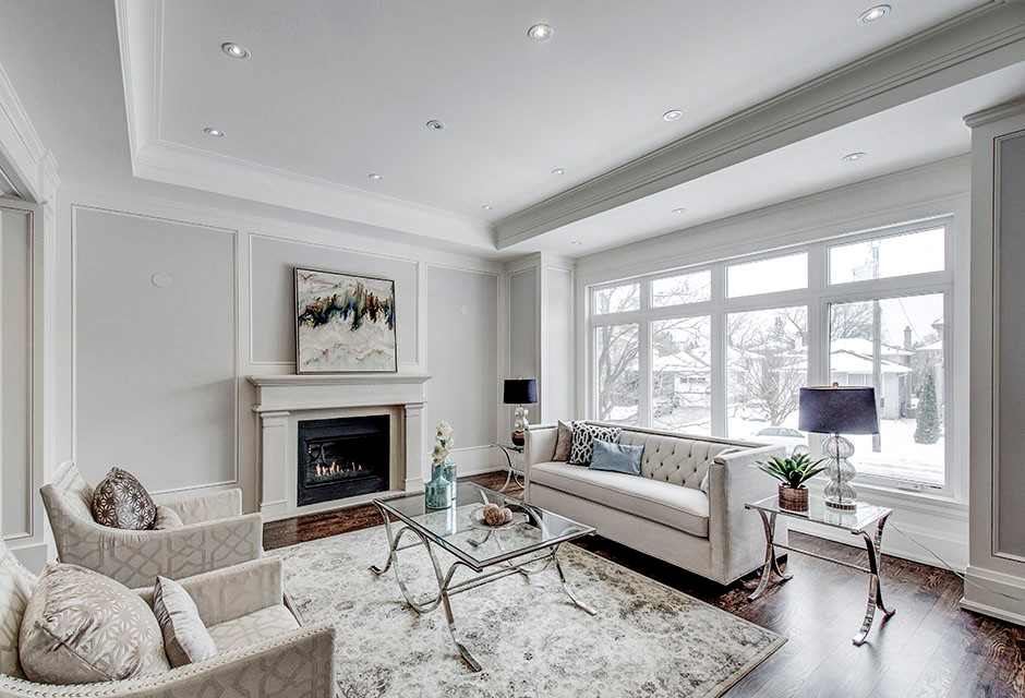 Inspiration for a mid-sized transitional formal enclosed living room in Toronto with white walls, dark hardwood floors, a standard fireplace, a plaster fireplace surround, no tv and brown floor.