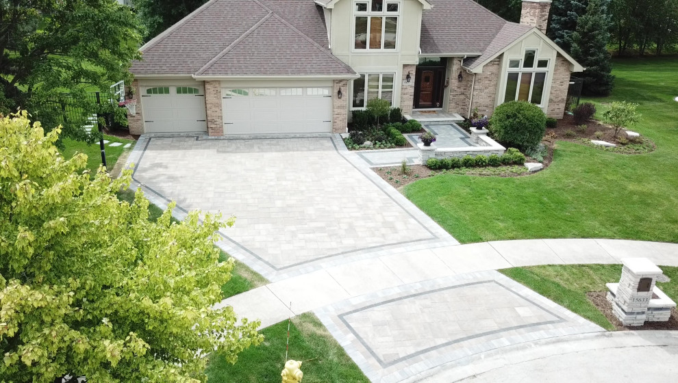 Design ideas for a large traditional front yard driveway in Chicago with with path and brick pavers.