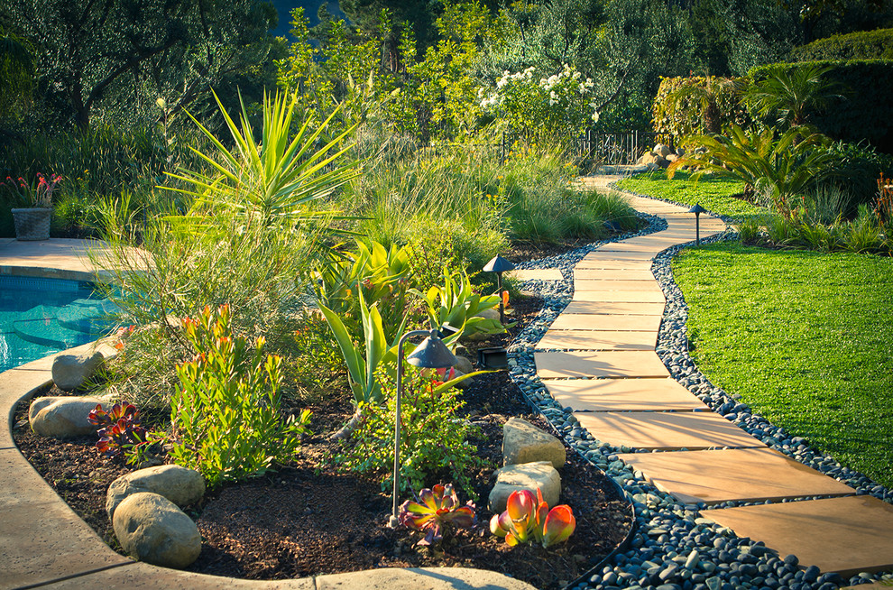 Photo of a large traditional backyard xeriscape in Los Angeles with a garden path and concrete pavers.