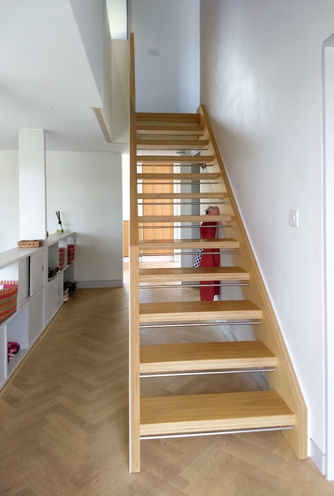 Inspiration for a mid-sized modern wood straight staircase in Hampshire with open risers and wood railing.