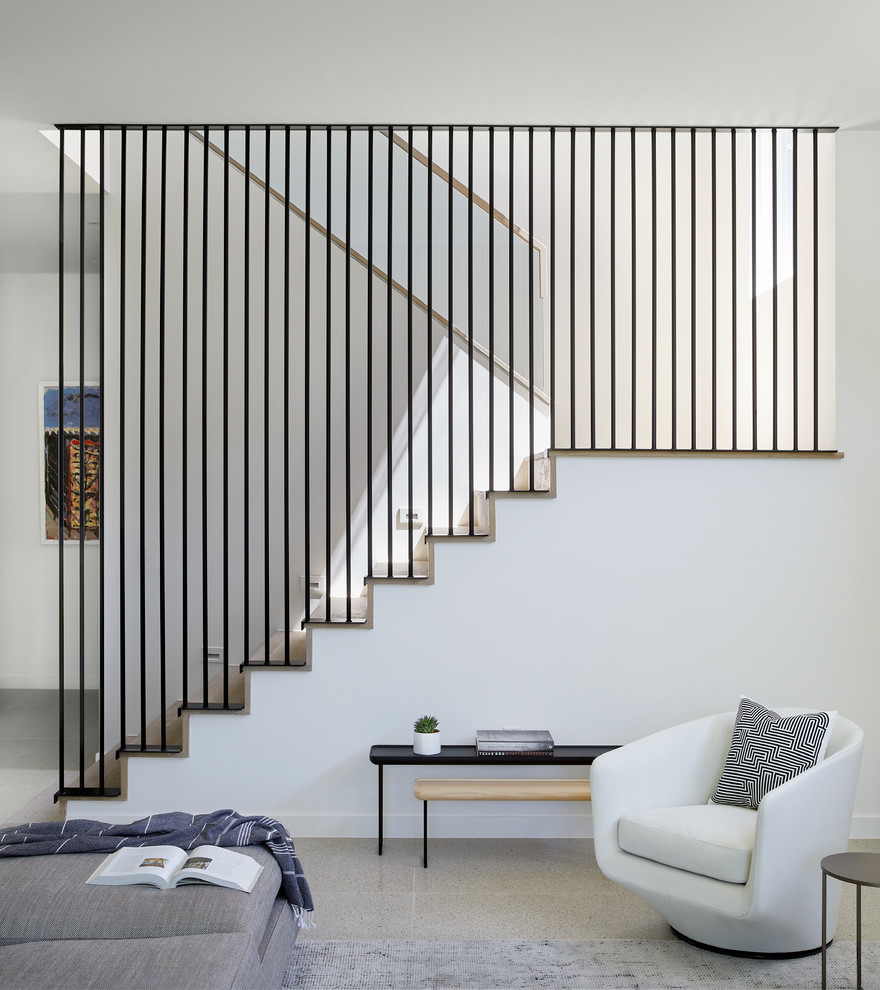 This is an example of a contemporary wood u-shaped staircase in Austin with wood risers and metal railing.