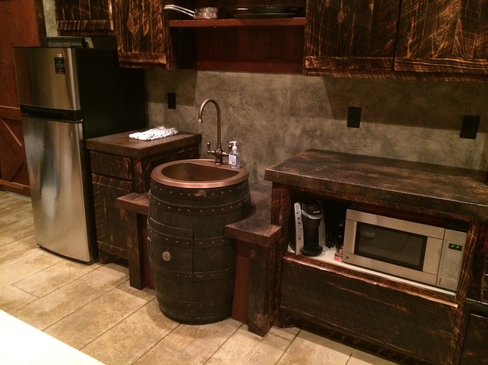 Inspiration for a small rustic single-wall beige floor and light wood floor open concept kitchen remodel with a farmhouse sink, dark wood cabinets, brown backsplash, stainless steel appliances, no island and brown countertops