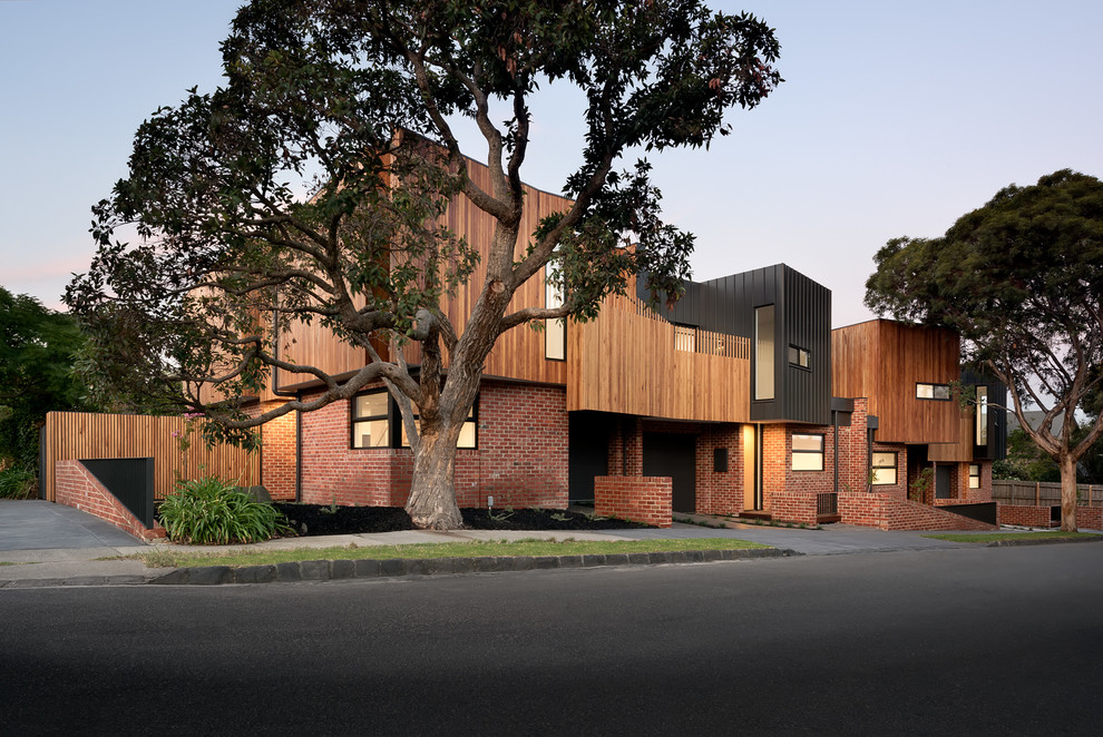 Photo of a mid-sized contemporary two-storey brick red exterior in Melbourne with a flat roof.