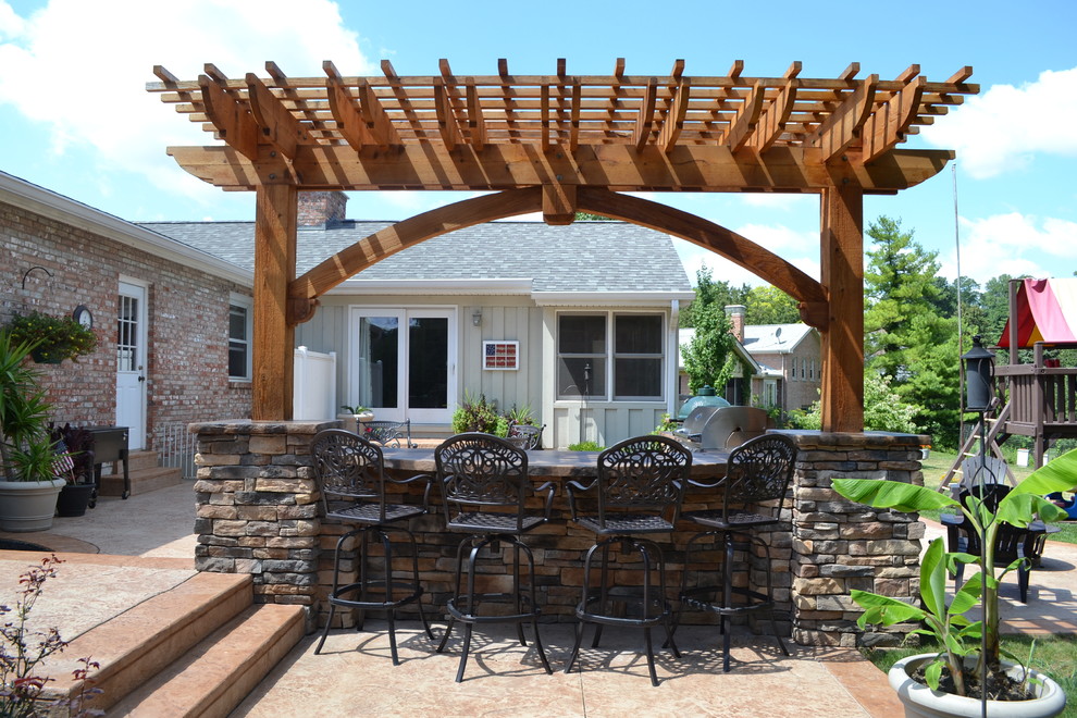 Mid-sized backyard patio in Cincinnati with an outdoor kitchen, stamped concrete and a pergola.