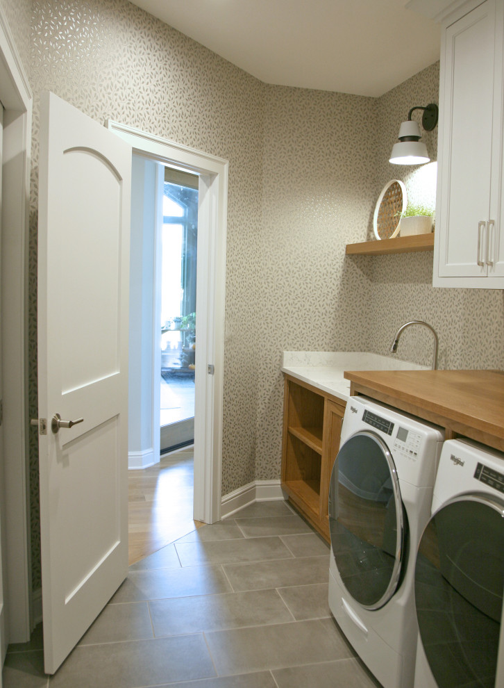 Mid-sized scandinavian single-wall dedicated laundry room in Milwaukee with an undermount sink, shaker cabinets, medium wood cabinets, quartz benchtops, white splashback, engineered quartz splashback, green walls, ceramic floors, a side-by-side washer and dryer, grey floor, white benchtop and wallpaper.