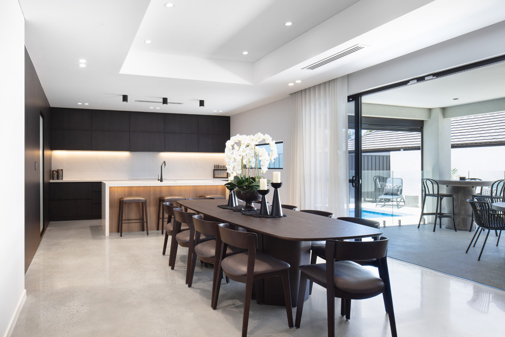 Идея дизайна: большая кухня-столовая в стиле модернизм с белыми стенами, бетонным полом, серым полом, многоуровневым потолком, панелями на стенах и фасадом камина из бетона без камина