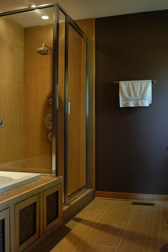 This is an example of a small asian master bathroom in Raleigh with flat-panel cabinets, light wood cabinets, a drop-in tub, a corner shower, a two-piece toilet, beige tile, porcelain tile, brown walls, porcelain floors, a vessel sink and granite benchtops.