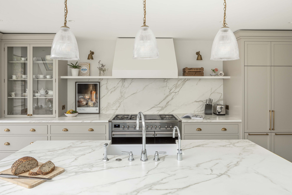 Inspiration for a large modern single-wall eat-in kitchen in London with a farmhouse sink, shaker cabinets, grey cabinets, solid surface benchtops, white splashback, marble splashback, stainless steel appliances, porcelain floors, with island, beige floor and white benchtop.